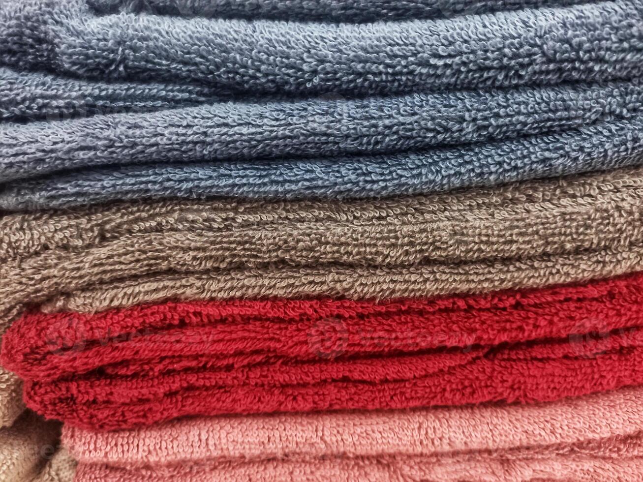 Stacks of clean, soft towels in a variety of colors photo