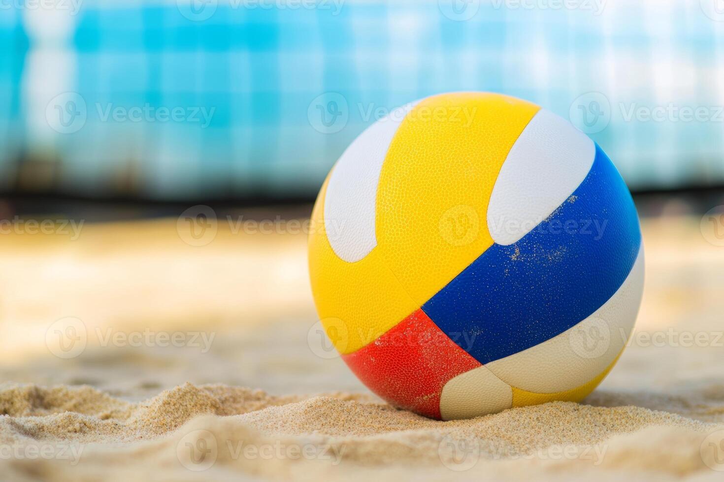 Colorful beach volleyball resting on sandy shore under the sun at a vibrant seaside location during the afternoon photo