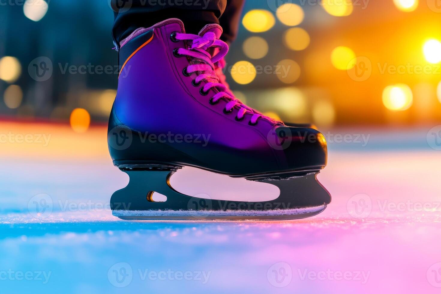 A close-up of a purple ice skate resting on the rink as colorful lights illuminate a winter evening skating session photo