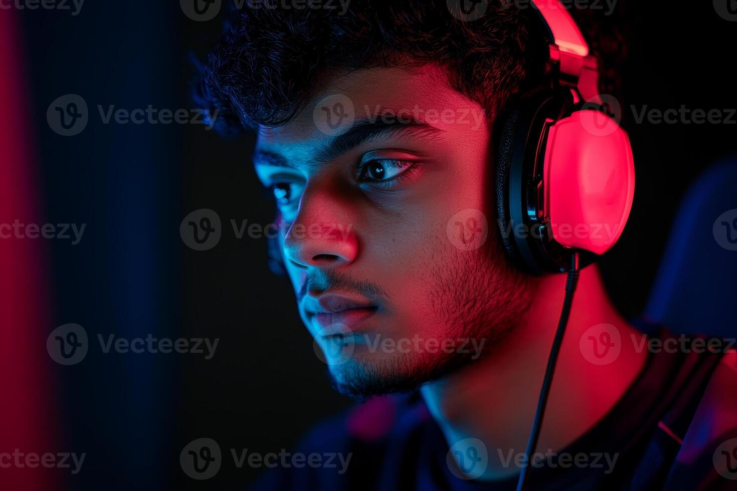 Teen boy focused on gaming while wearing headphones in a colorful room during the evening hours photo