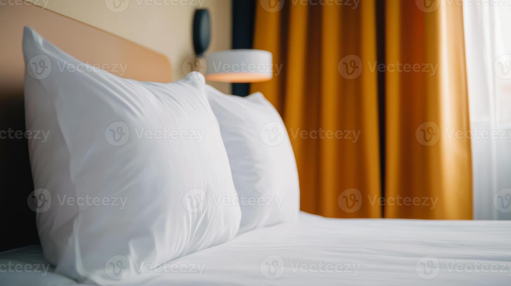 Cozy hotel room with soft white pillows and warm curtains in the late afternoon light photo