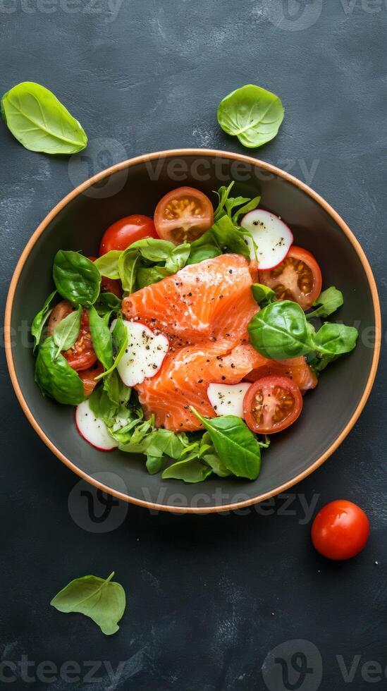 Fresh salmon salad featuring vibrant greens and cherry tomatoes served in a rustic bowl against a dark background photo