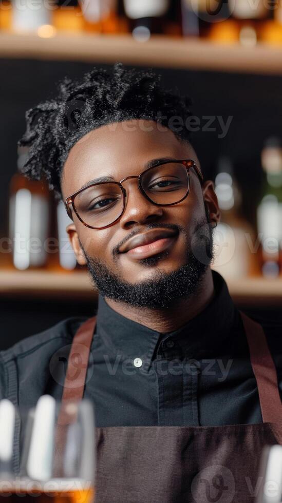 A smiling bartender in a black shirt serves customers at a bustling bar during the evening hours photo