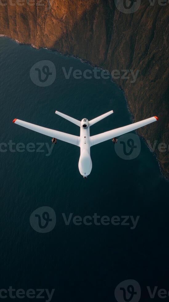 Drone flying over the ocean near a rugged coastline during golden hour capturing stunning aerial views of nature and the landscape photo