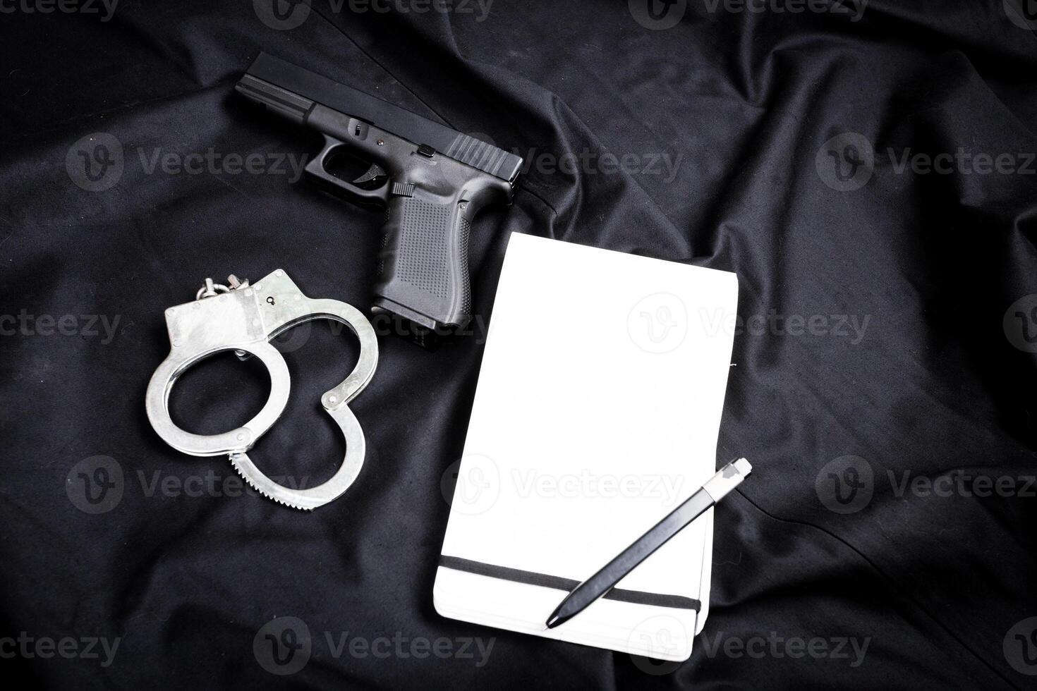 Rifle, gun, knife with sheath, compass and notebook with pen on on black cloth photo