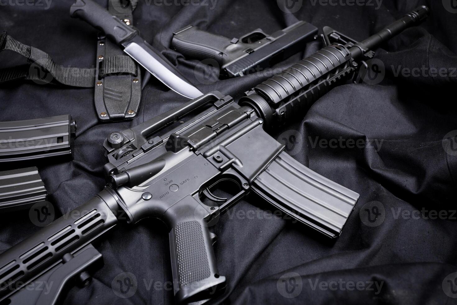 Rifle, gun, knife with sheath, compass and notebook with pen on on black cloth photo