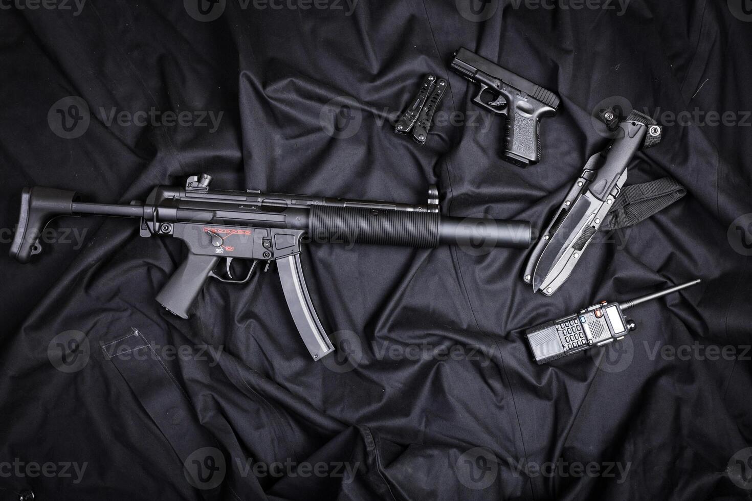 Rifle, gun, knife with sheath, compass and notebook with pen on on black cloth photo