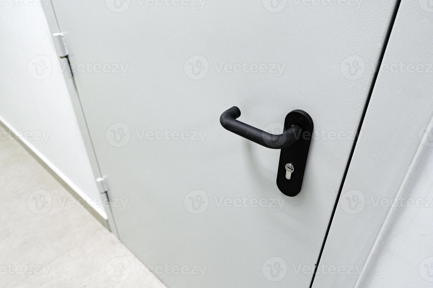 Close-up view of a sleek door handle on a modern white door in a minimalist interior setting photo