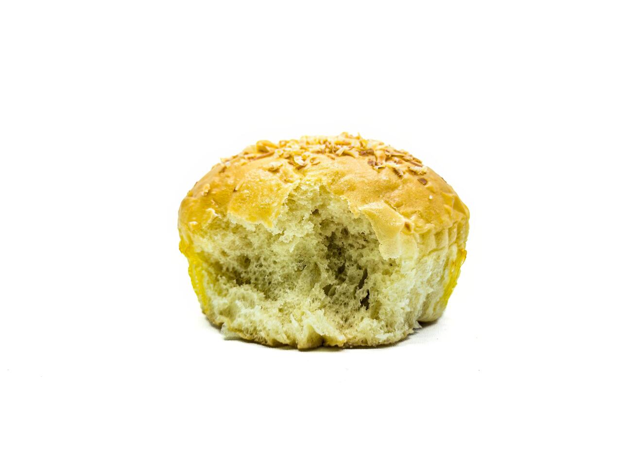 A close up image of a partially eaten sesame seed bun on a white background. The texture of the bread is soft and fluffy, with a golden brown crust sprinkled with sesame seeds photo