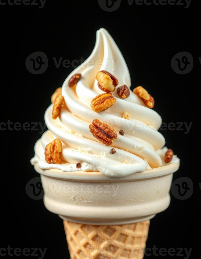 Creamy soft serve ice cream topped with crunchy pecans in a waffle cone served against a black background photo