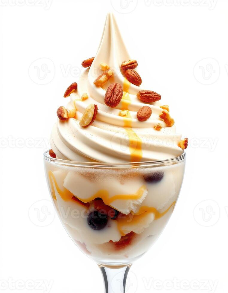 Delicious soft serve dessert topped with nuts and caramel sauce in a clear glass dish photo