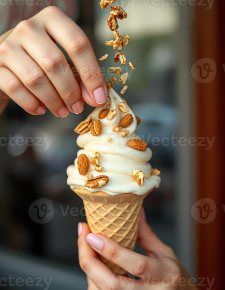 Swirling soft serve ice cream cone topped with crunchy nuts held by hands in a vibrant setting photo