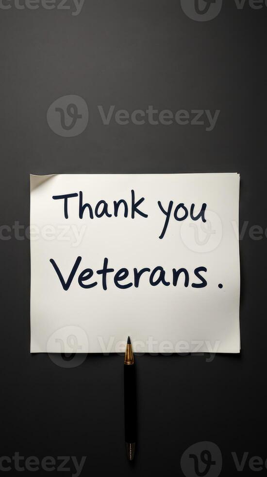 Message of gratitude to veterans displayed on a paper note pinned to a dark surface photo