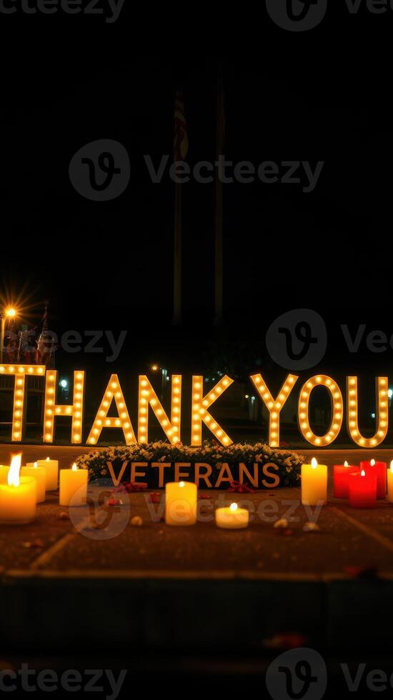Brightly lit message honoring veterans at a nighttime memorial event with candles photo