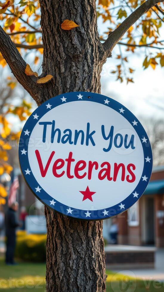 Thank you veterans sign attached to a tree in a local park during autumn with yellow leaves falling photo
