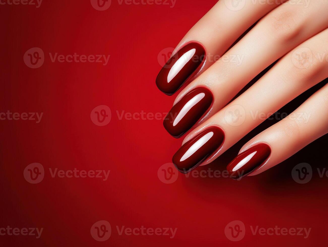 Deep red manicure showcasing shiny nails against a vibrant red background for a bold beauty statement photo