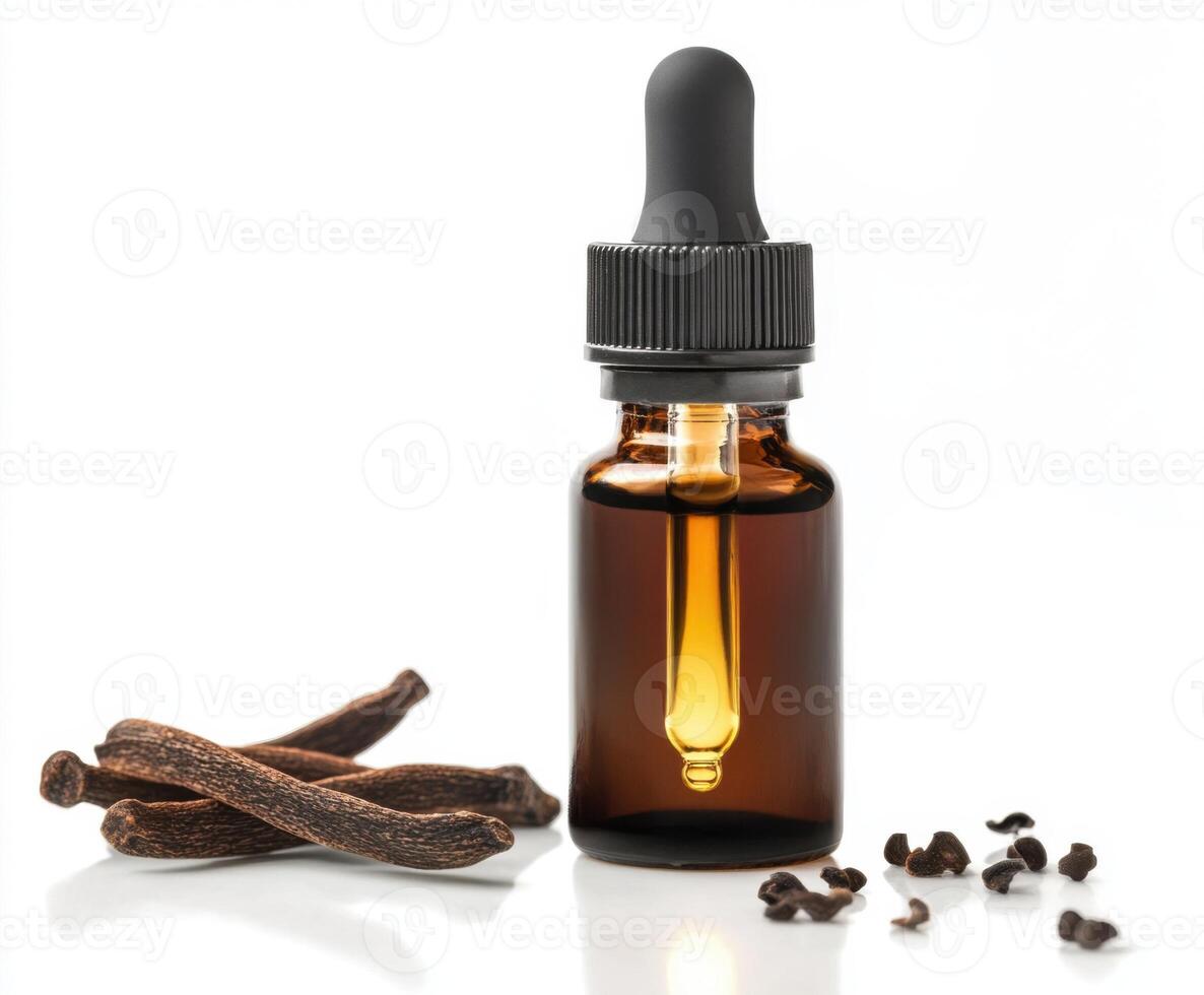 Essential oil bottle with dropper next to vanilla beans and cloves on white surface photo