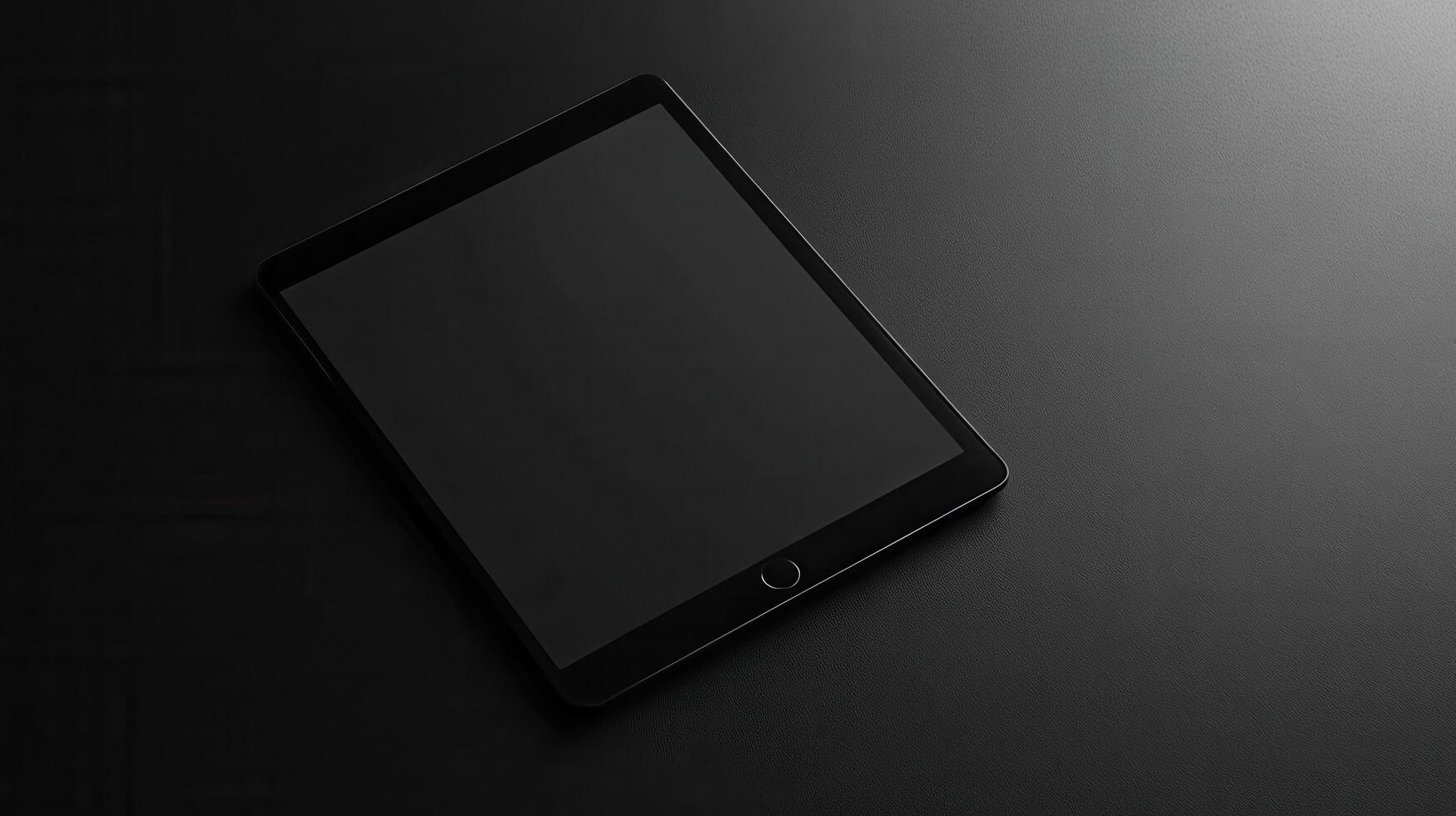 Elegant black tablet resting on a dark surface, showcasing modern technology in a minimalist setting photo
