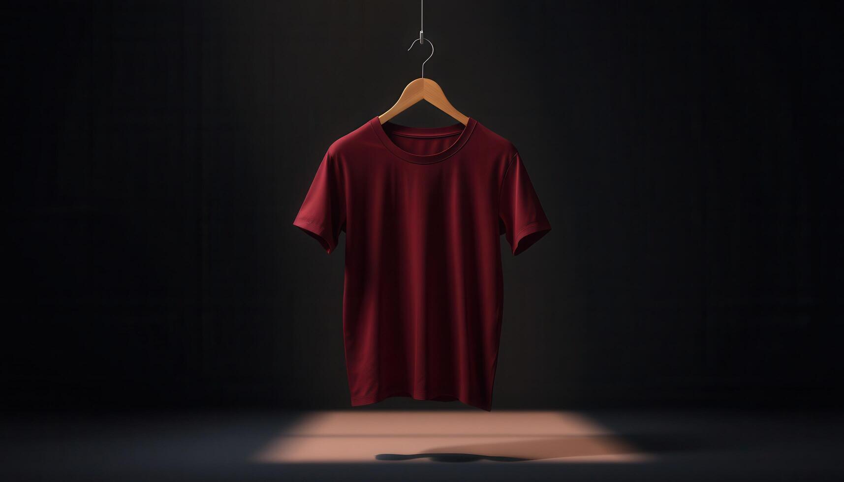 A maroon t-shirt hanging on a wooden hanger in a dark room with a spotlight on the floor photo