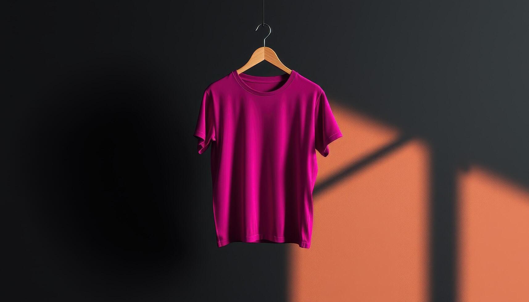 A Pink T-Shirt Hanging on a Wooden Hanger in a Studio photo
