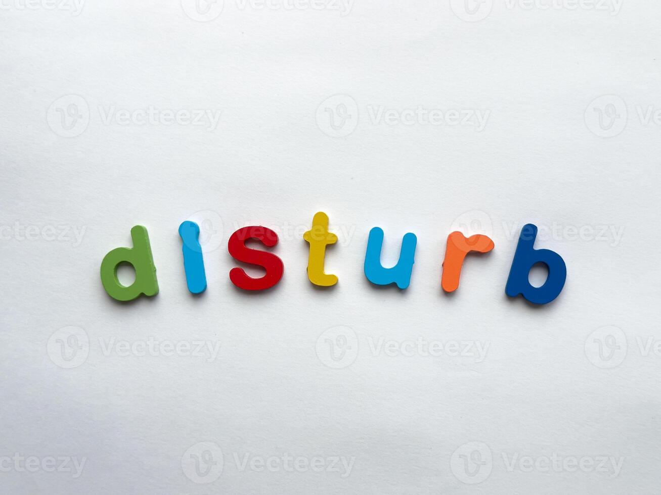 Colorful alphabet letters spell disturb on white background photo