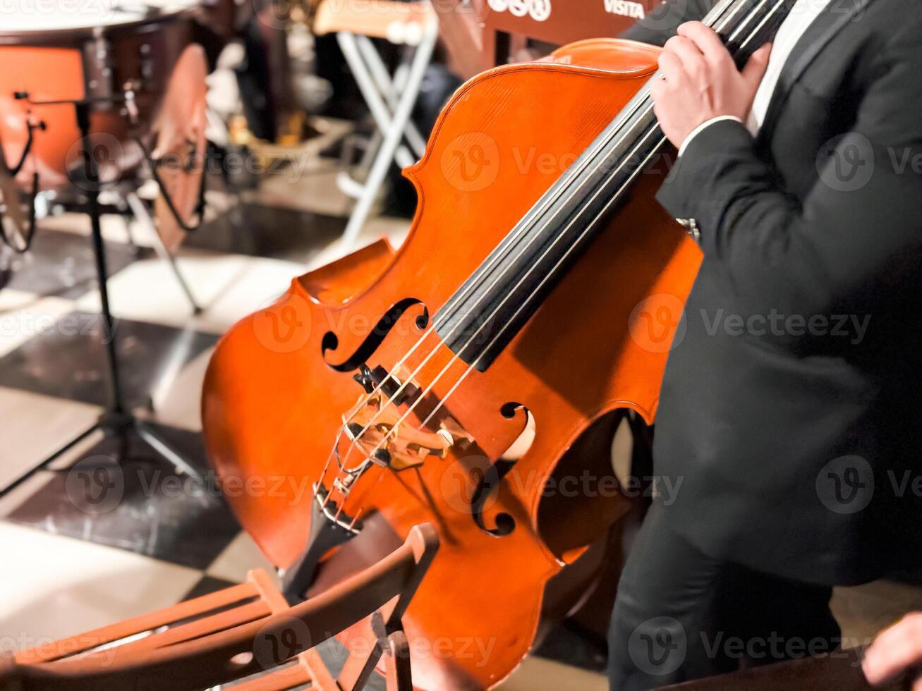 Male musician playing cello at indoor classical music performance photo