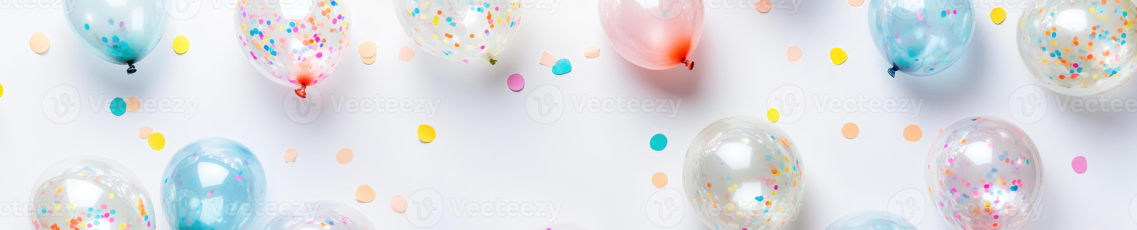 Festive overhead flat lay of clear balloons with colorful confetti for celebrations and party designs photo
