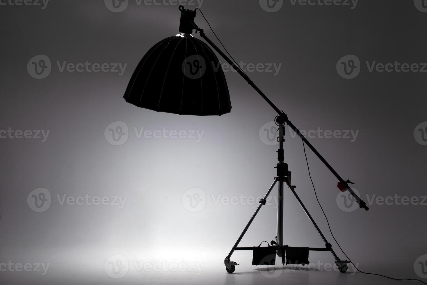 Studio lighting equipment with a large black softbox on a stand, dramatic atmosphere in a photography studio photo