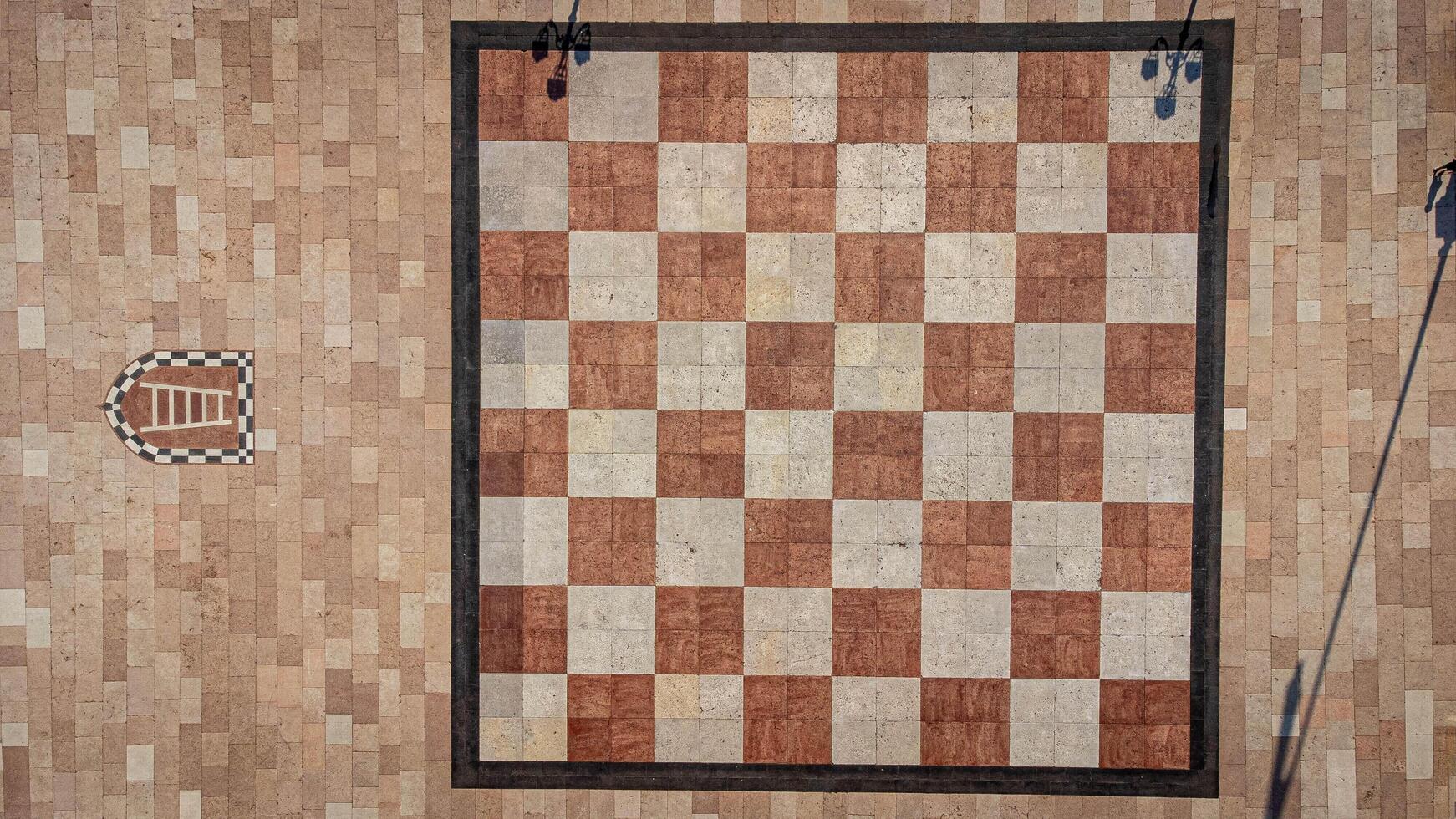Large chessboard seen from above. Chess square in the center of Marostica, a medieval town in Italy. Texture and background of chessboard squares photo