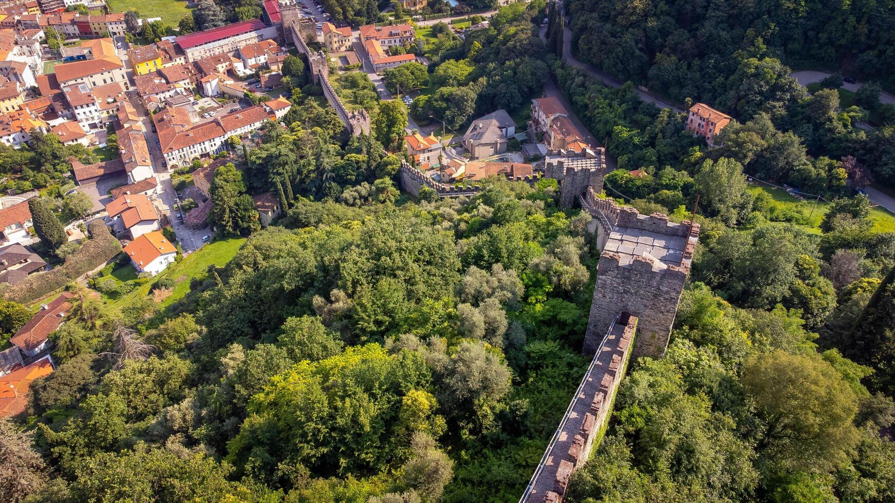Medieval walls seen from above in the middle of the forest. Aerial view of ancient city walls going up the mountain. Walls of the castle of Marostica, Italy photo