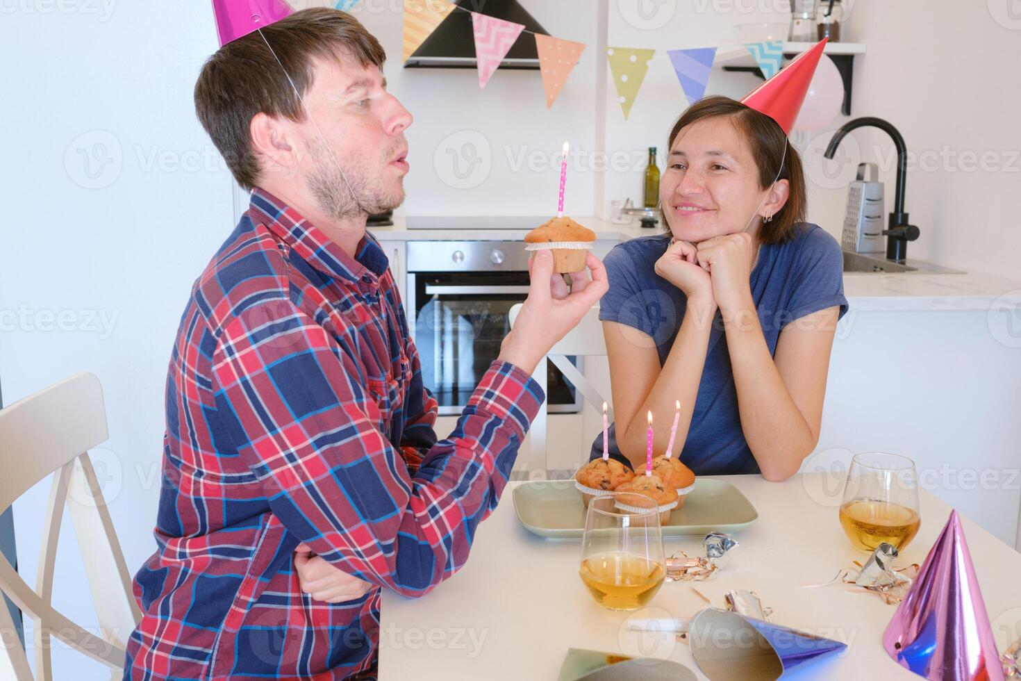 family sits together in beautifully decorated dining room, blowing out candles on birthday cake. joyful celebration radiates warmth and togetherness in festive, homey atmosphere. photo