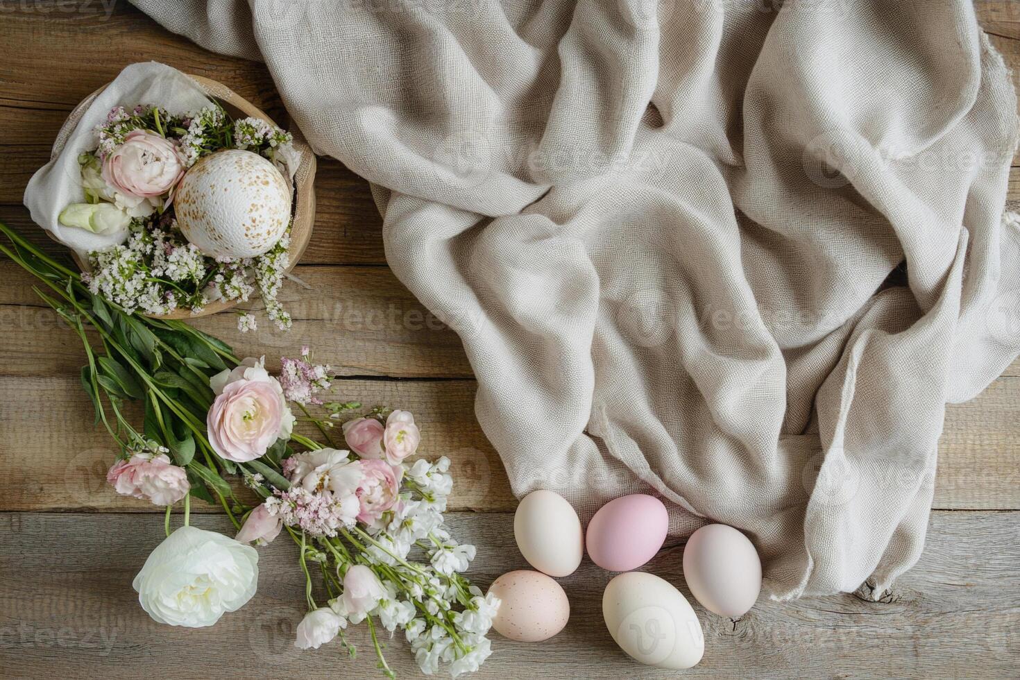 A rustic Easter arrangement featuring pastel eggs on a wooden surface with soft linen and delicate flowers. The warm tones and natural textures create a peaceful atmosphere. photo