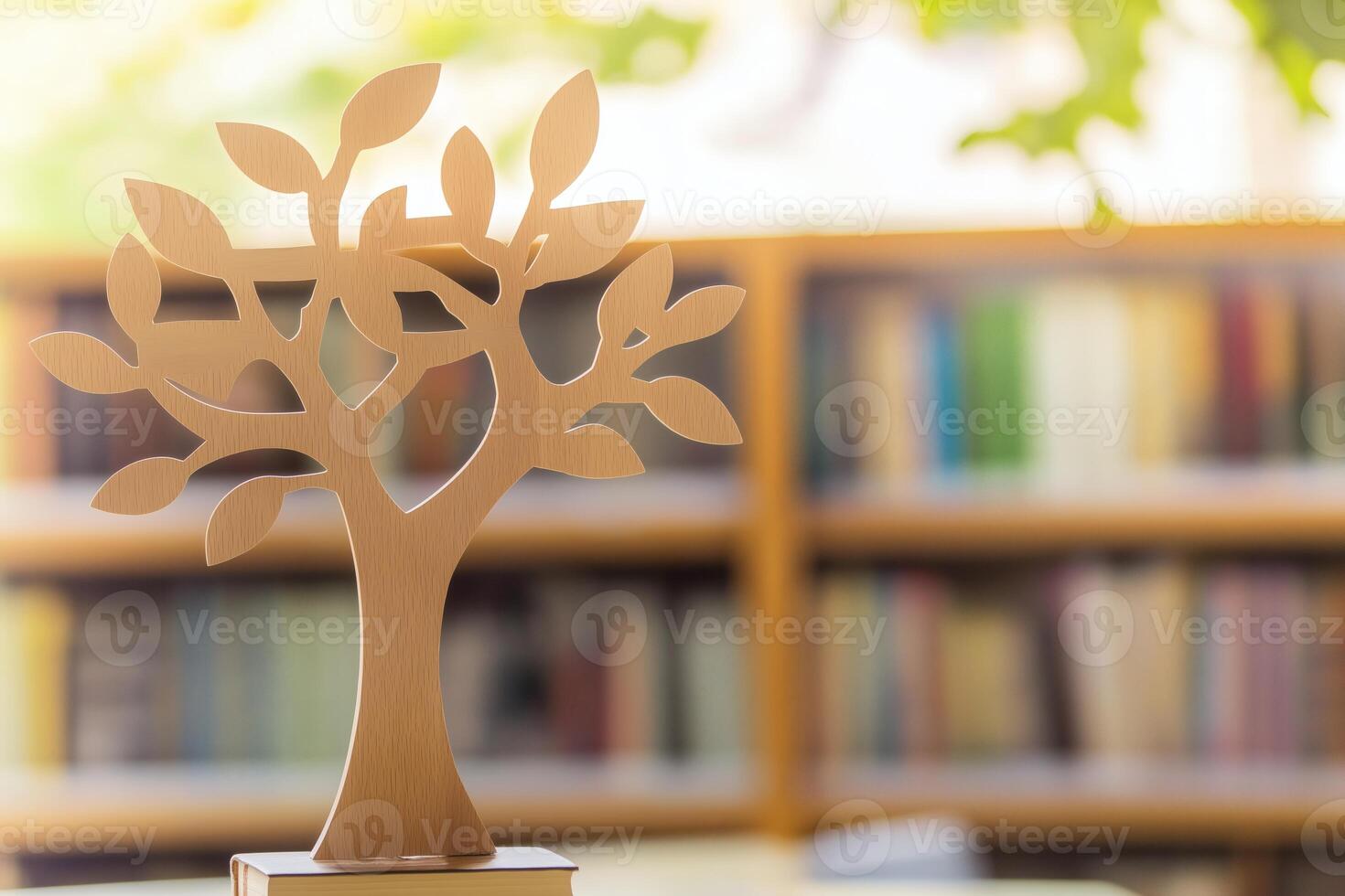 A wooden tree on a table in front of a bookcase photo