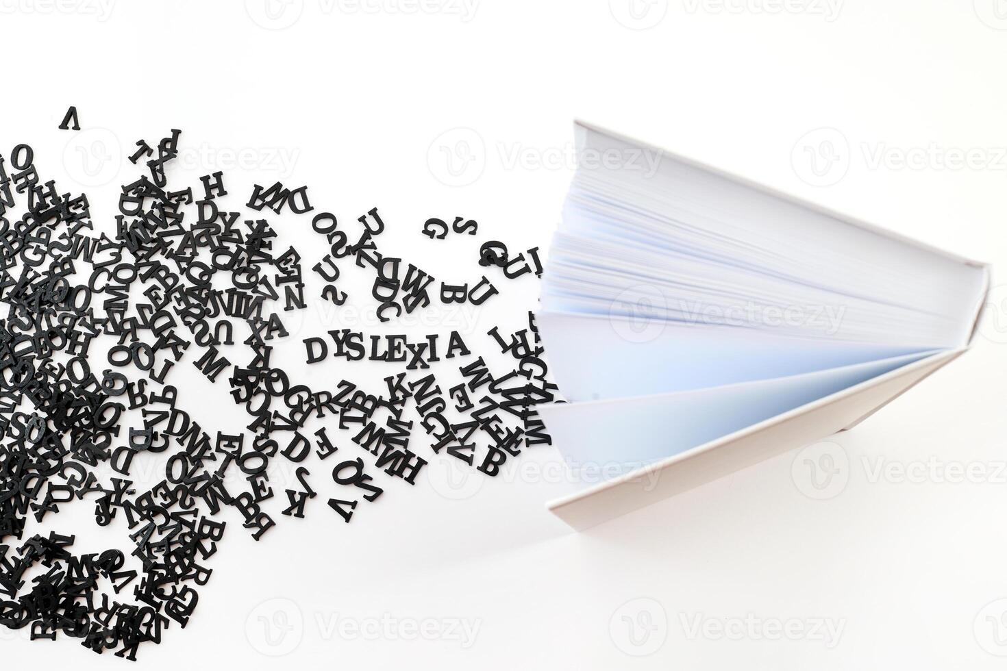 Dyslexia and Words. Open book with scattered letters symbolizing dyslexia photo