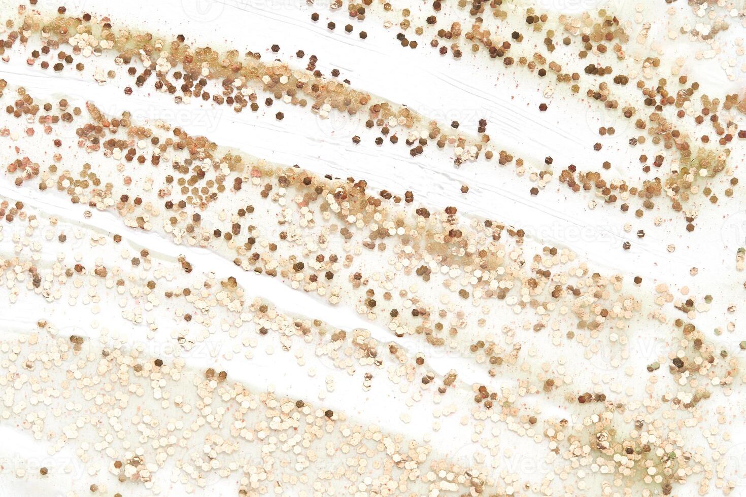 Abstract gold and beige glitter pattern on white background creates elegant textured effect. photo