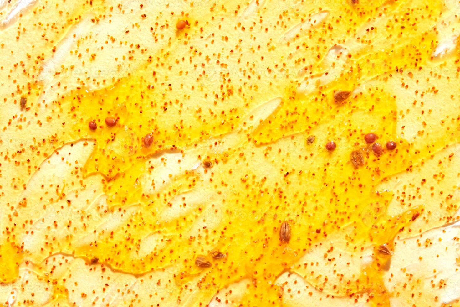 Close up of honeycomb with golden honey drizzle and pollen granules creating natural texture. photo