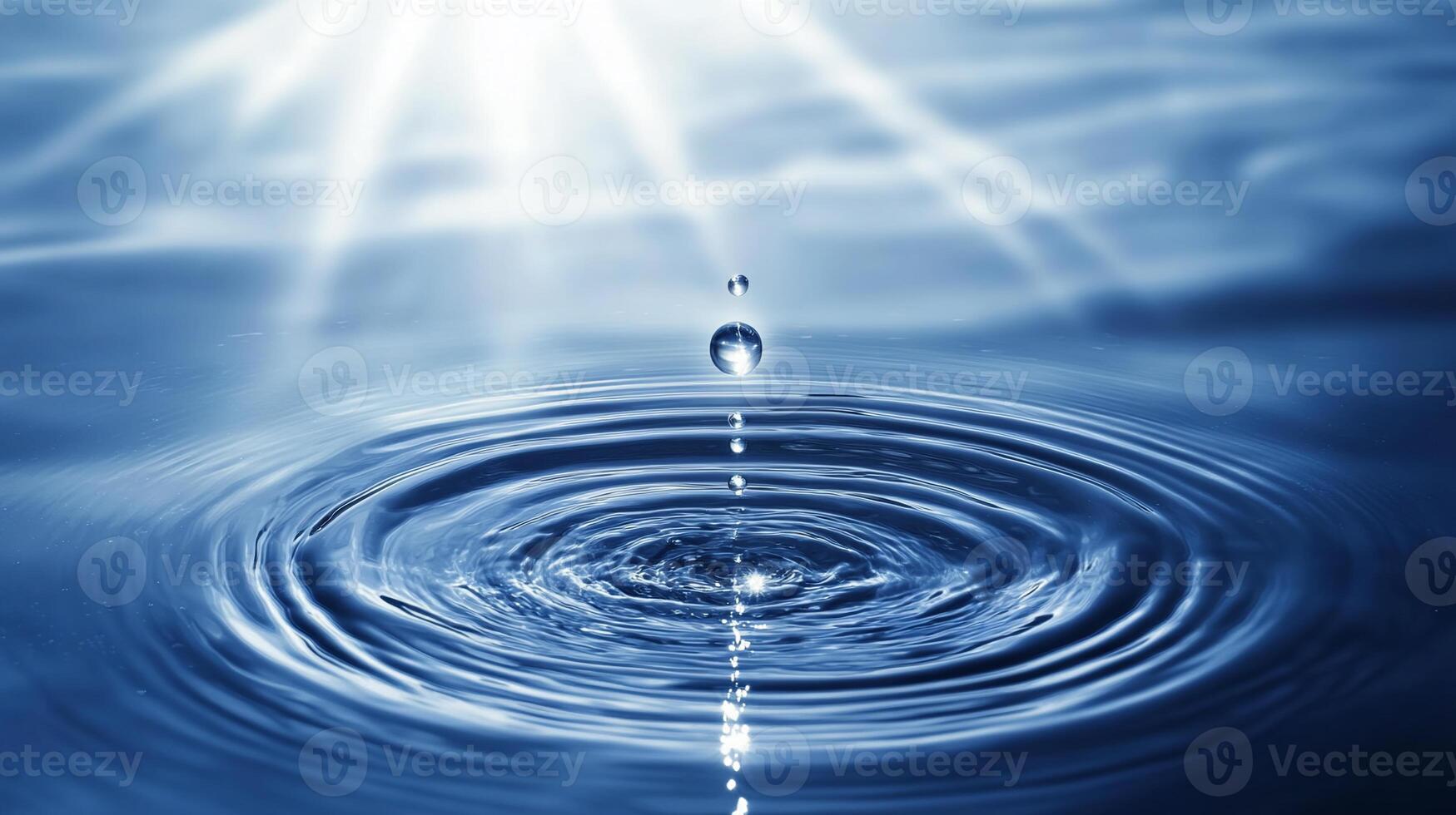 Water droplet falling, creating concentric ripples on a calm surface, backlit by sunlight. photo