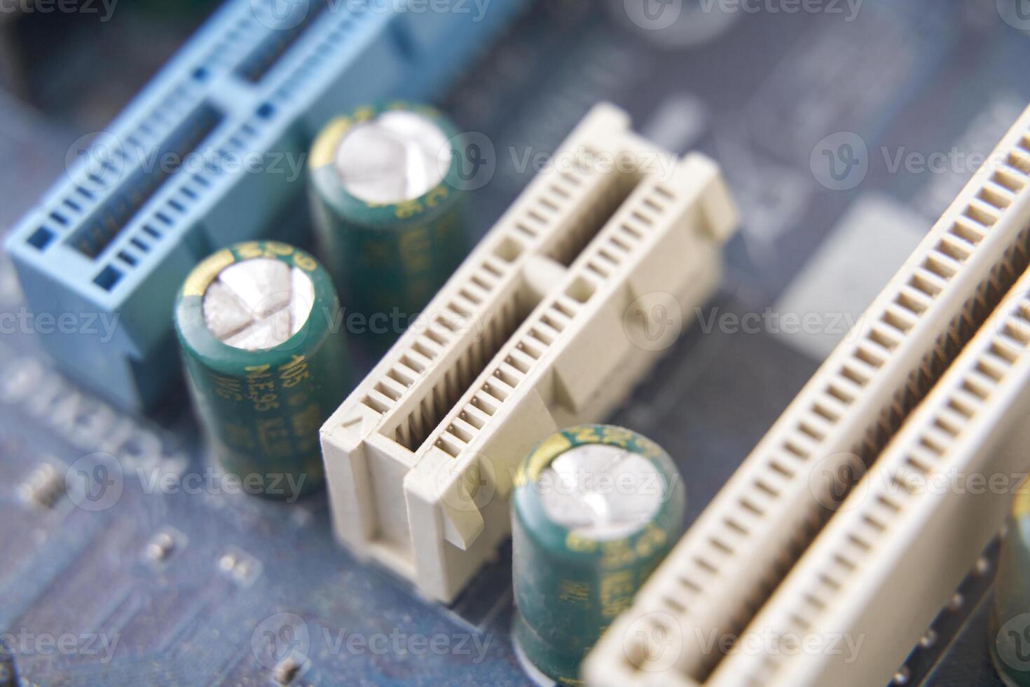 Close up of computer motherboard with capacitors and pci slots in focus. photo
