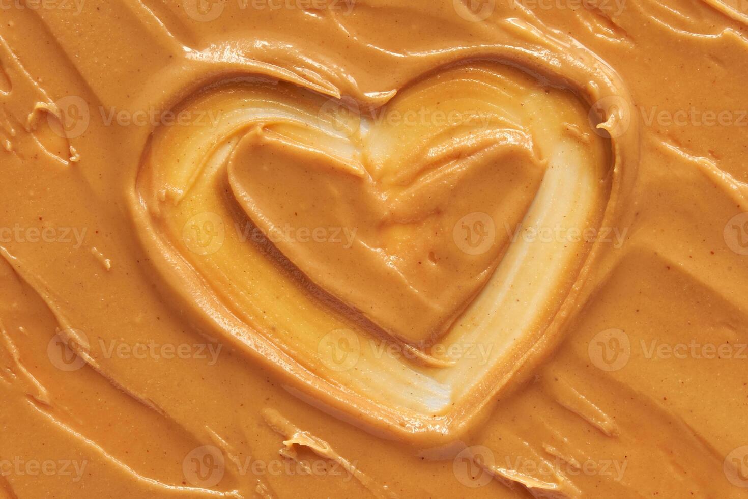 Heart shaped swirl in smooth creamy peanut butter spread for food and culinary arts concepts. photo