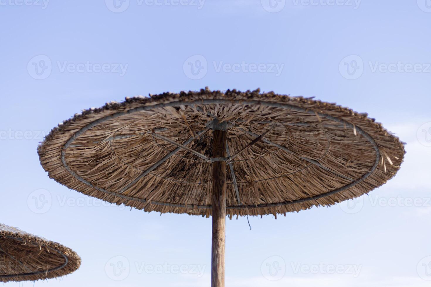 straw umbrellas on the beach close up photo