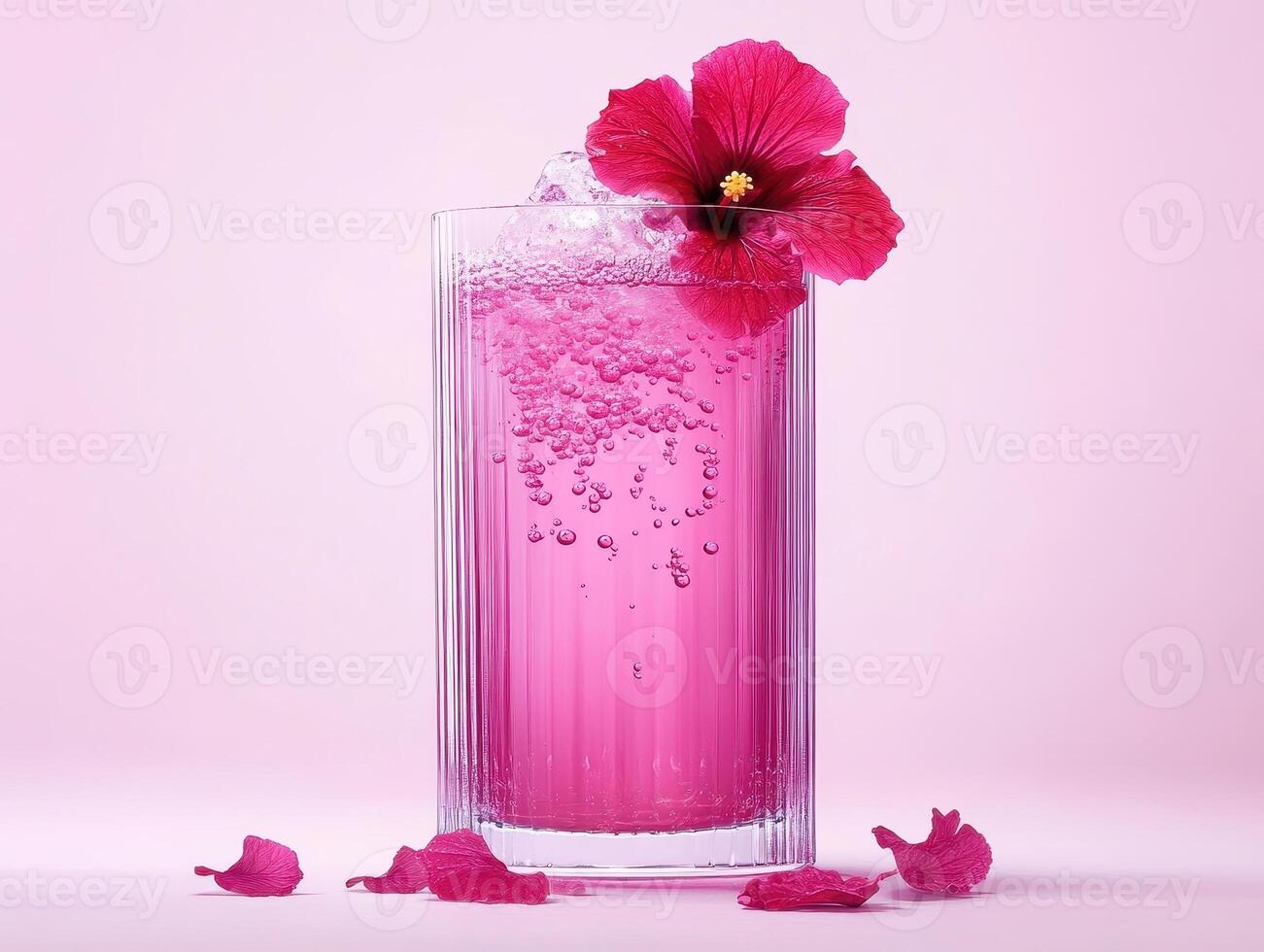 Refreshing hibiscus tea in tall glass, adorned with vibrant flower, surrounded by petals. pink hues create cheerful and inviting atmosphere photo