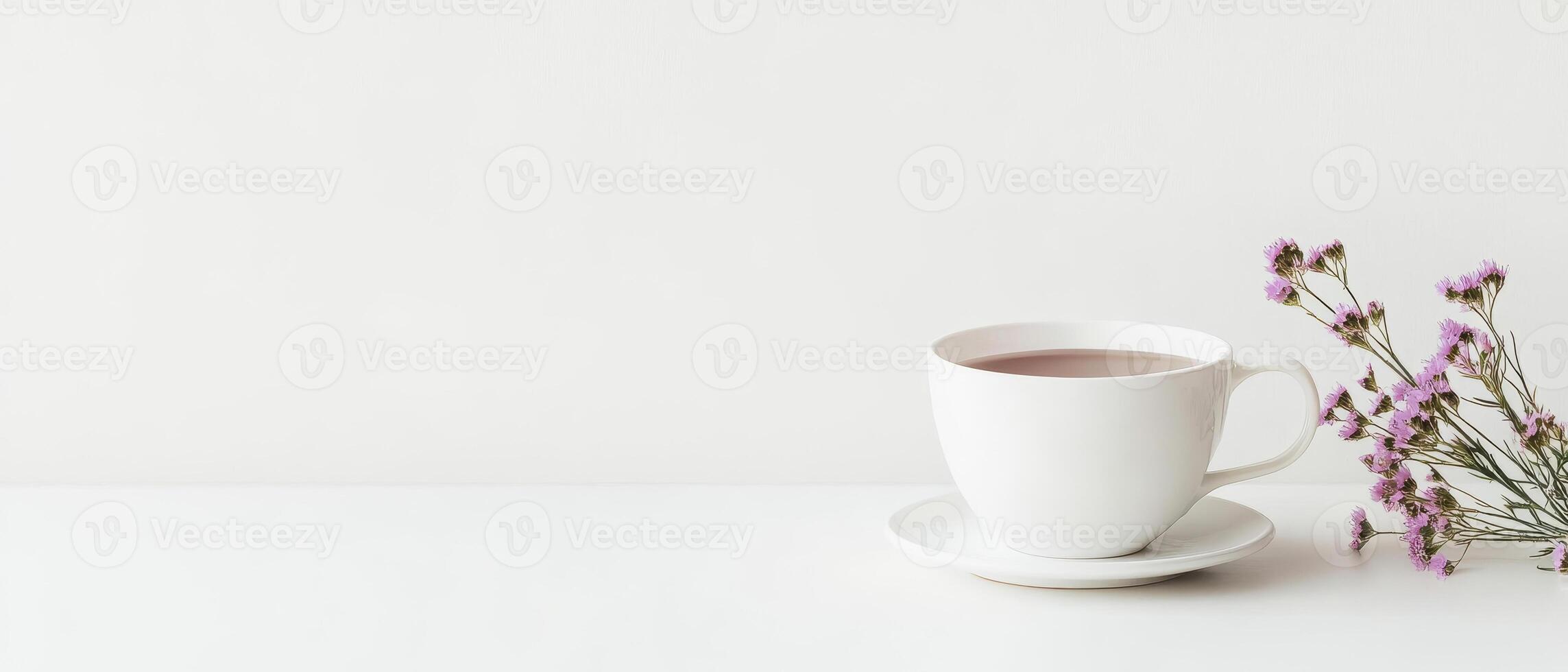 minimalist white tea cup with saucer, accompanied by delicate purple flowers, creates serene and elegant atmosphere. This composition is perfect for tea lovers and those who appreciate simplicity photo