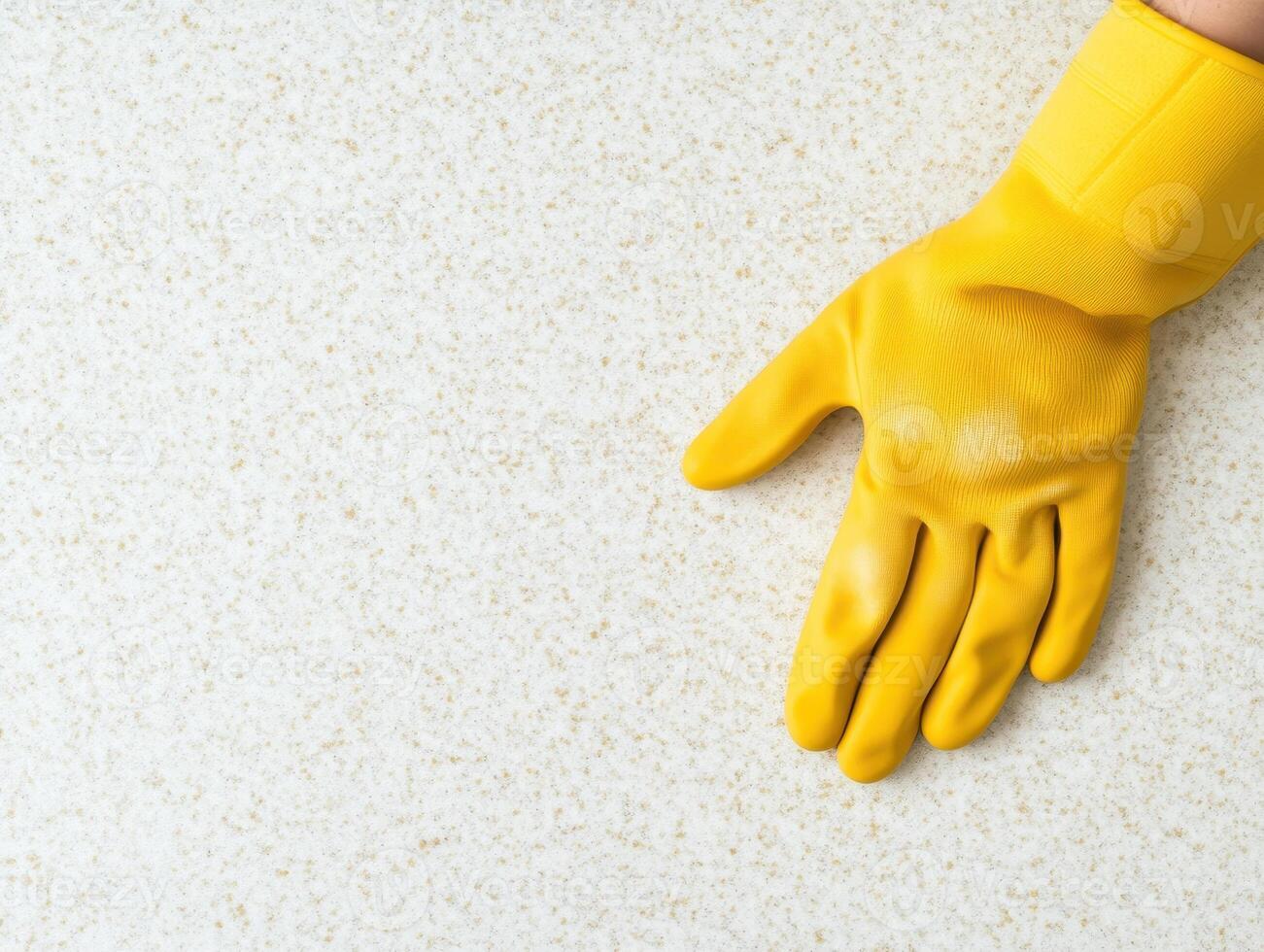 close up of yellow rubber glove resting on light textured surface, symbolizing cleanliness and protection. vibrant color adds cheerful touch to cleaning context photo