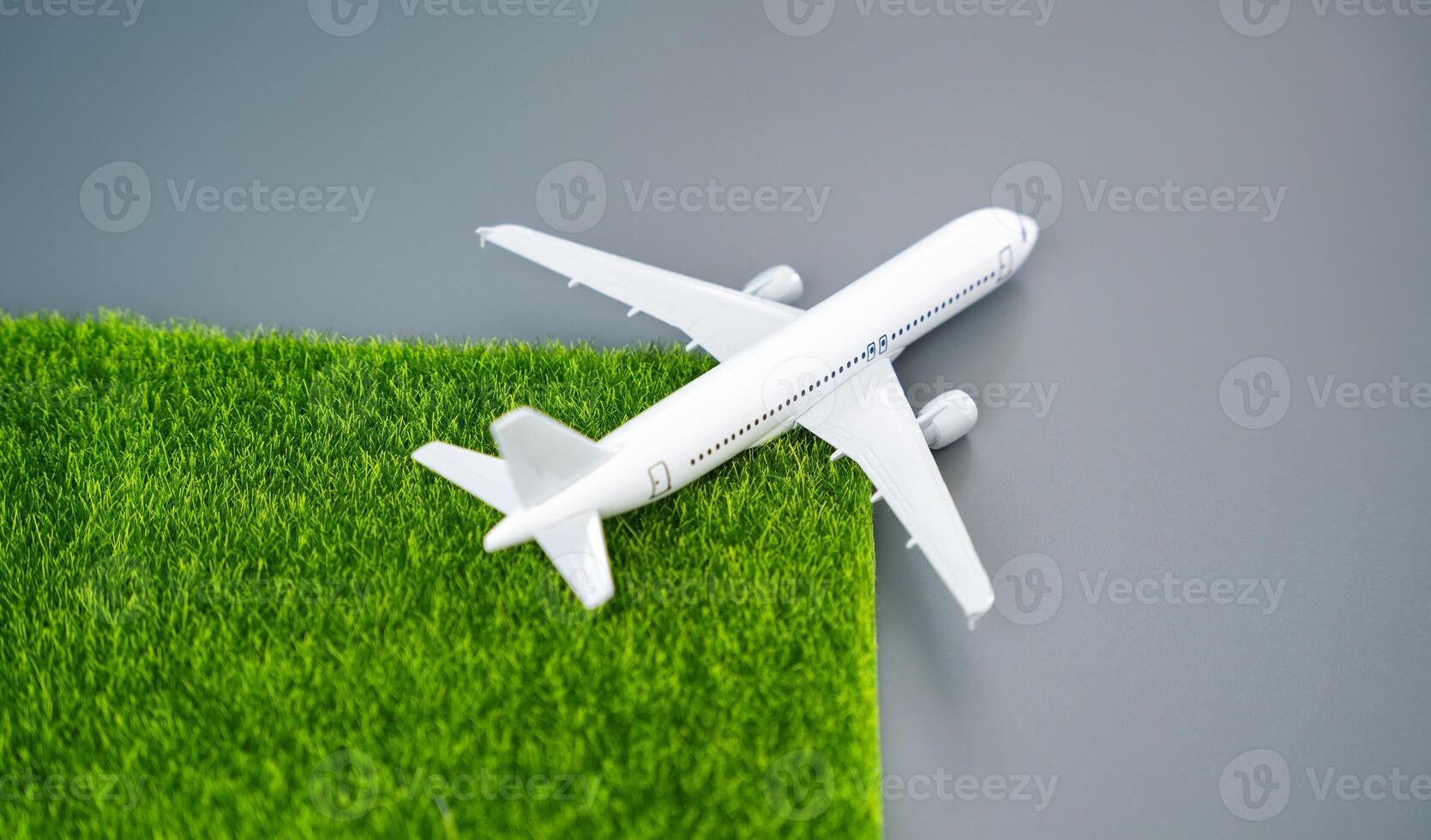 A passenger plane leaves green grass in its wake. Concept of environmental friendliness and clean emissions. Transition to environmentally friendly fuels, electric traction. Technological innovations photo