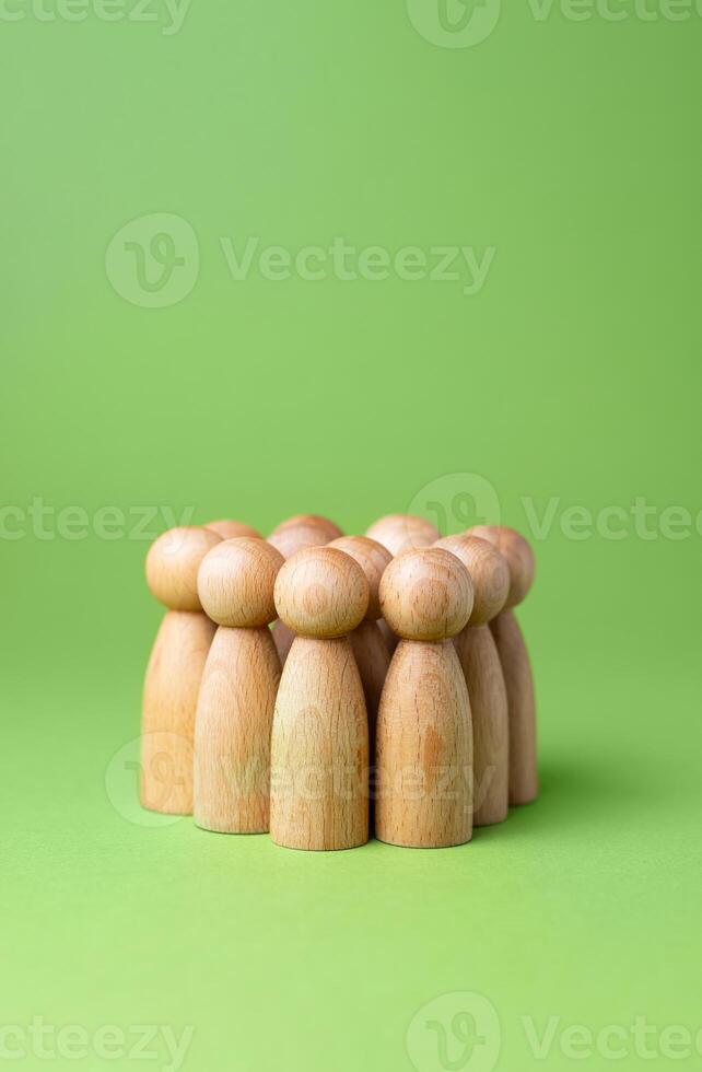 A group of human figures on a green background. Minimalism. Sociology and sciences. Human resources. Recruiting workers and hiring employees. Consumers and marketing. photo