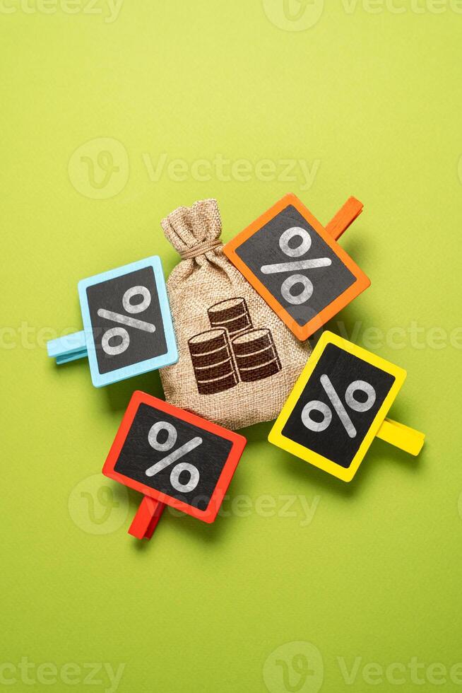 High debts and deductions. High tax burden. Money bag and a lot of interest attached. The highest interest rate on the deposit. Personal finance, taxation policy, and investment strategies. photo