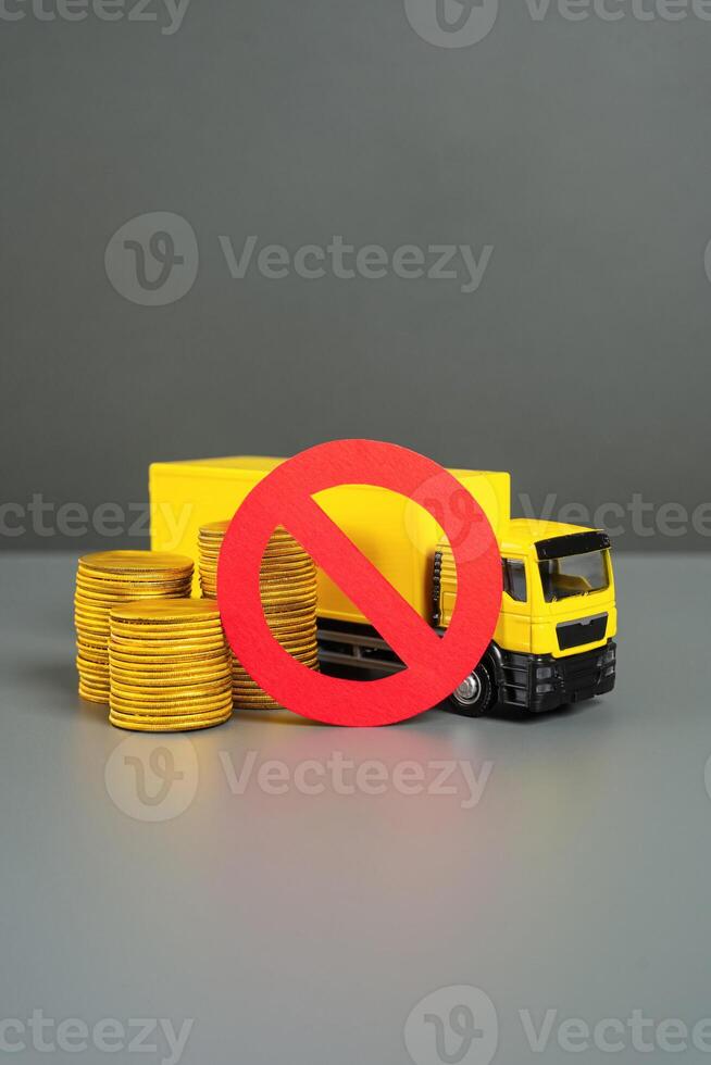 Truck with money and prohibition symbol. Freight restrictions. Transit ban. Sanctions. Truck with coins and red no sign. Embargo. Interference with trade routes, threat logistics. photo