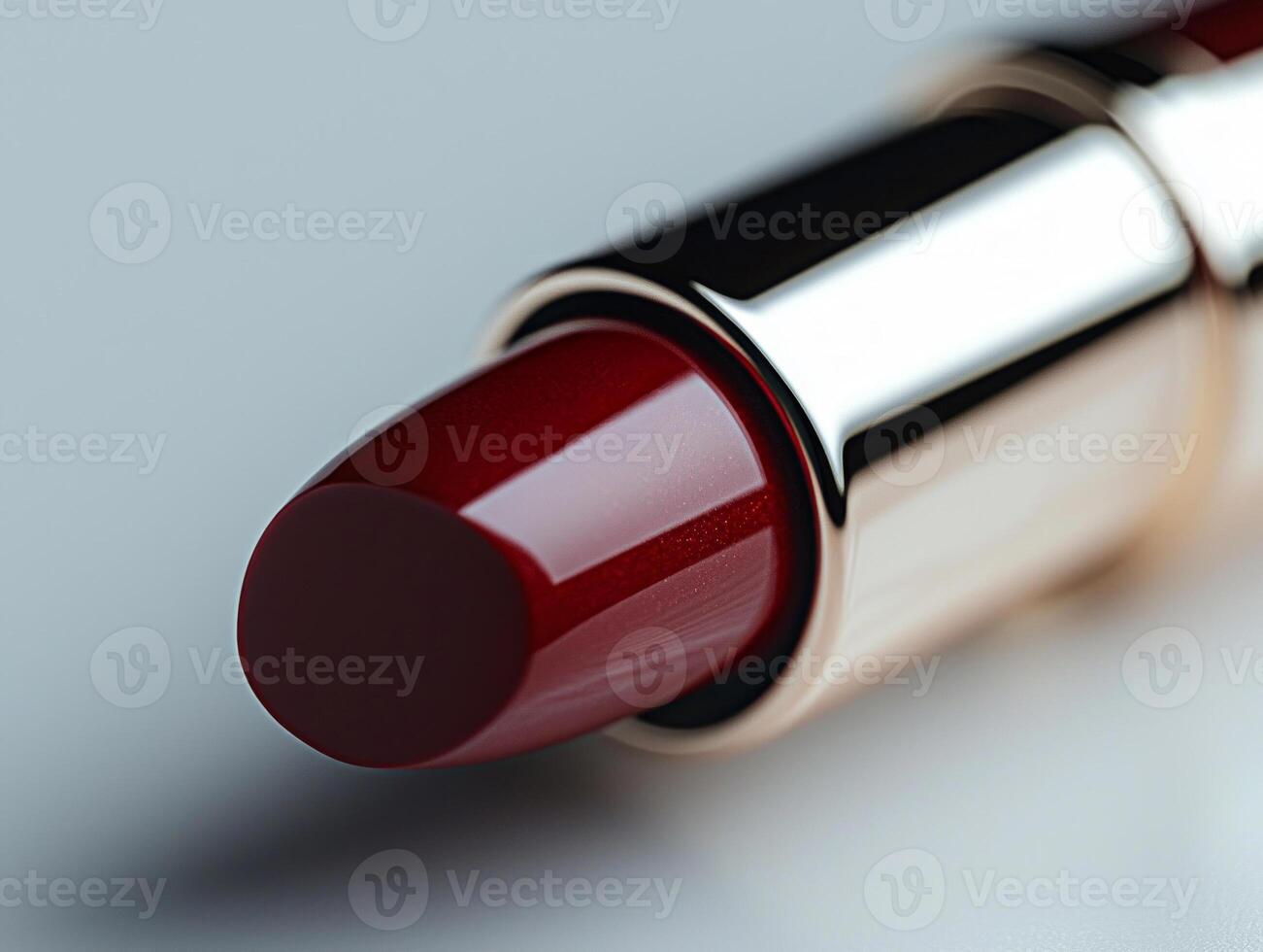 macro view captures rich red lipstick bullet featuring branded logo on tip. minimalist white backdrop emphasizes its luxurious design and pigmentation photo