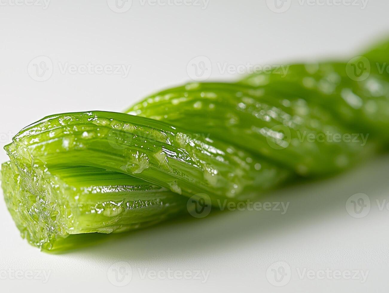 single celery stalk is shown in detail showcasing its ribbed texture and fresh green hue. clean white background enhances its natural appeal emphasizing freshness photo