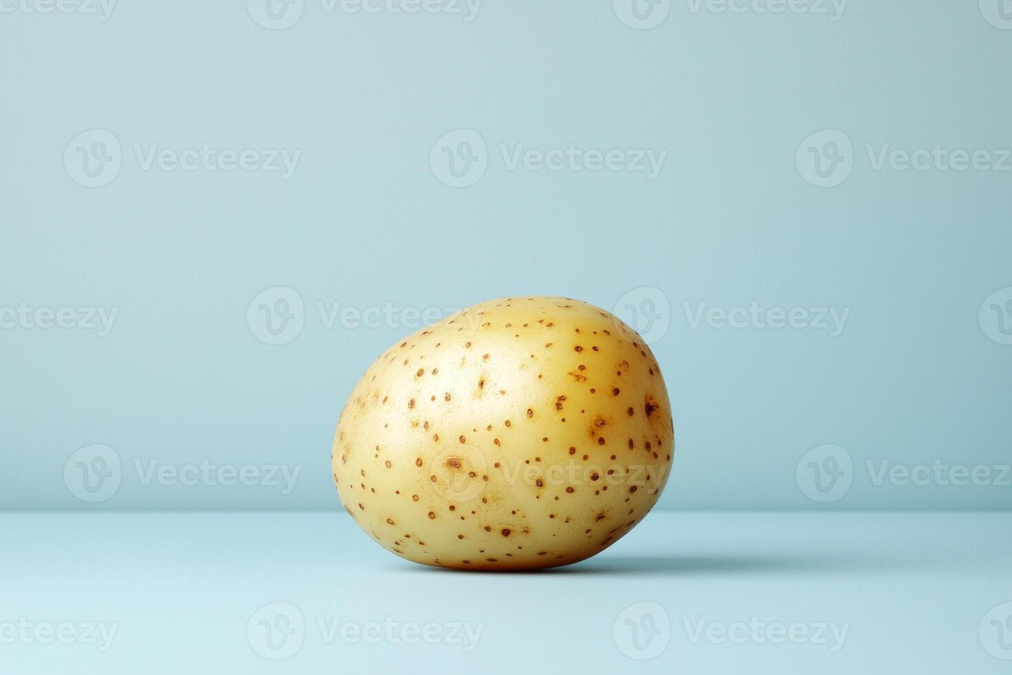 Focus on single golden potato reveals its rough earthy surface and natural blemishes. clean white backdrop enhances subject's details and authenticity photo